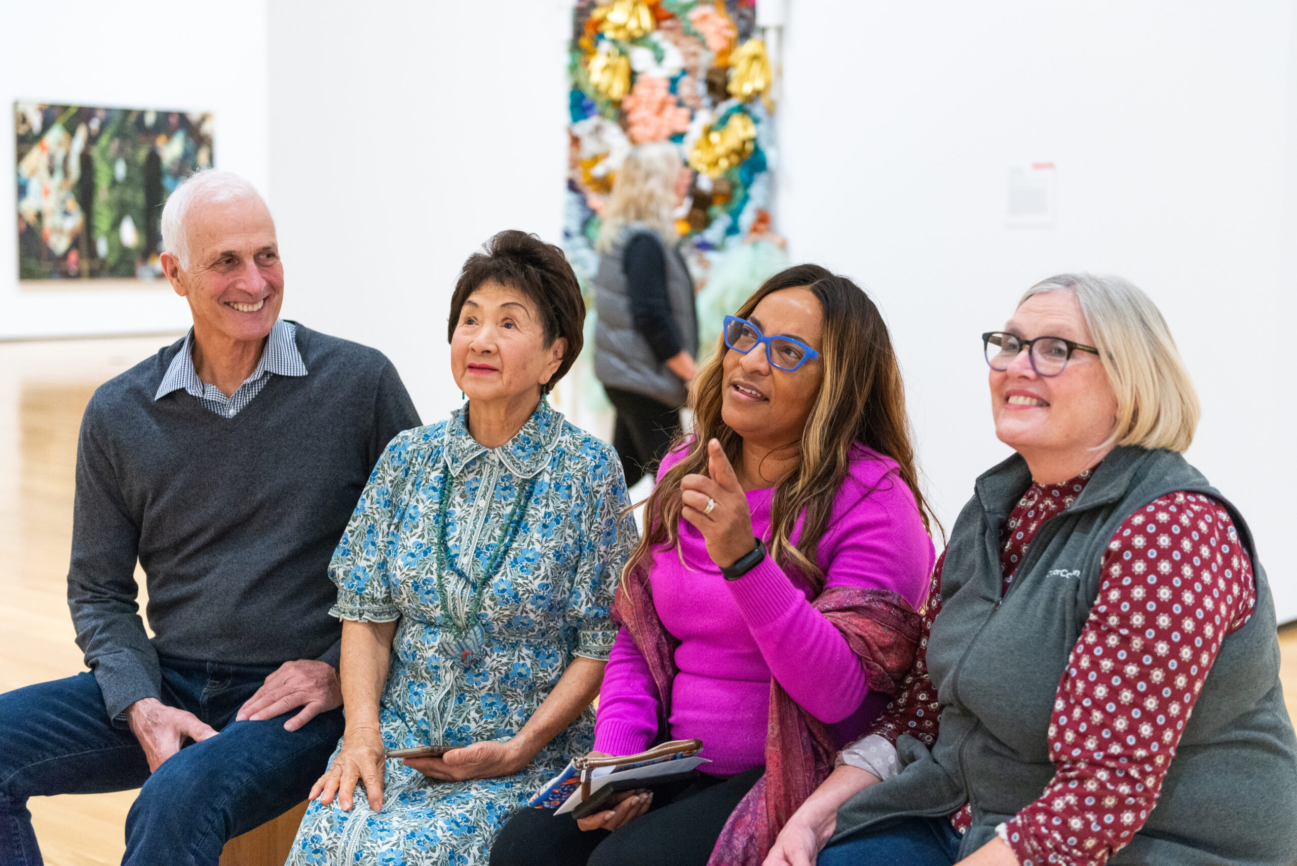 Photo of four diverse people discussing the arts in an art gallery