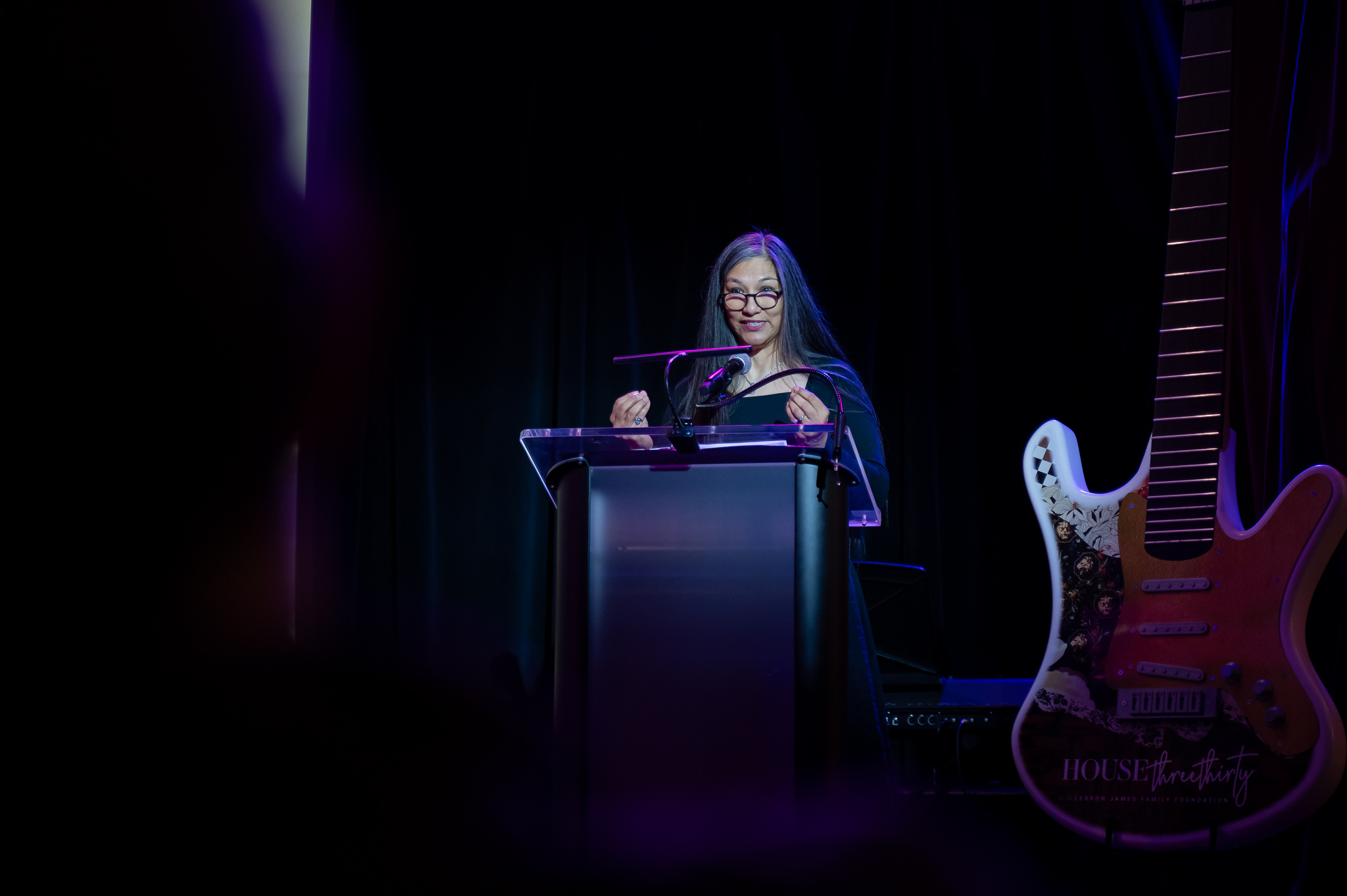 Photo of a woman speaking on stage at a conference 