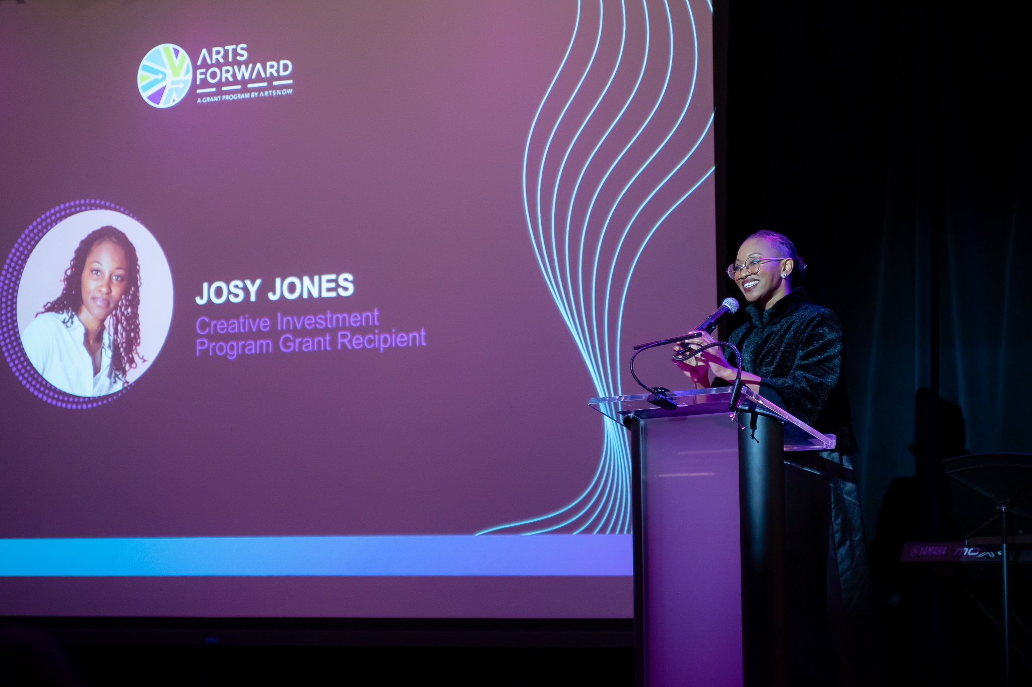 A woman speaking behind a podium at a conference
