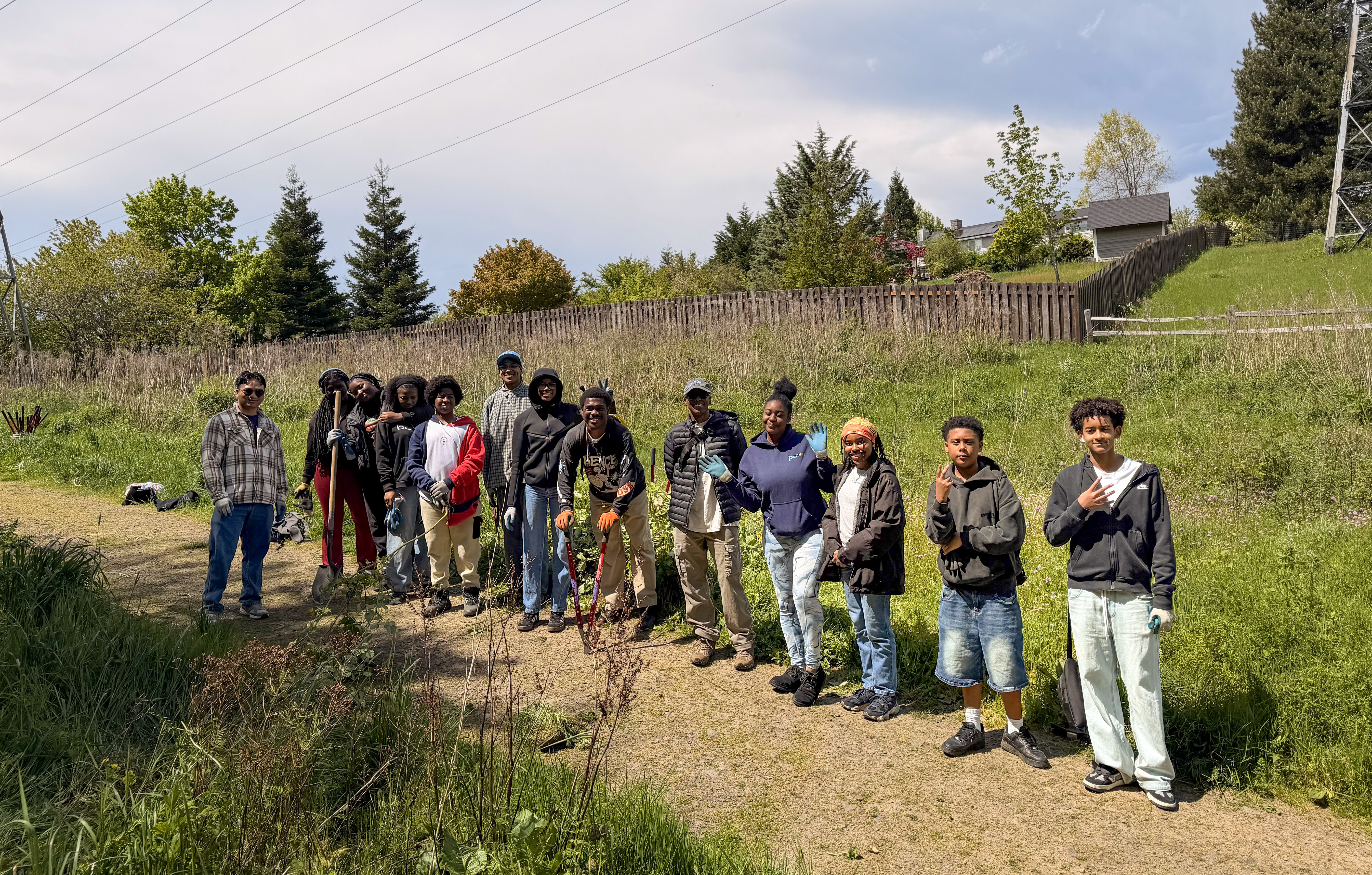 A large group of Blueprint students and mentors lined up for a photo in a grassy field.