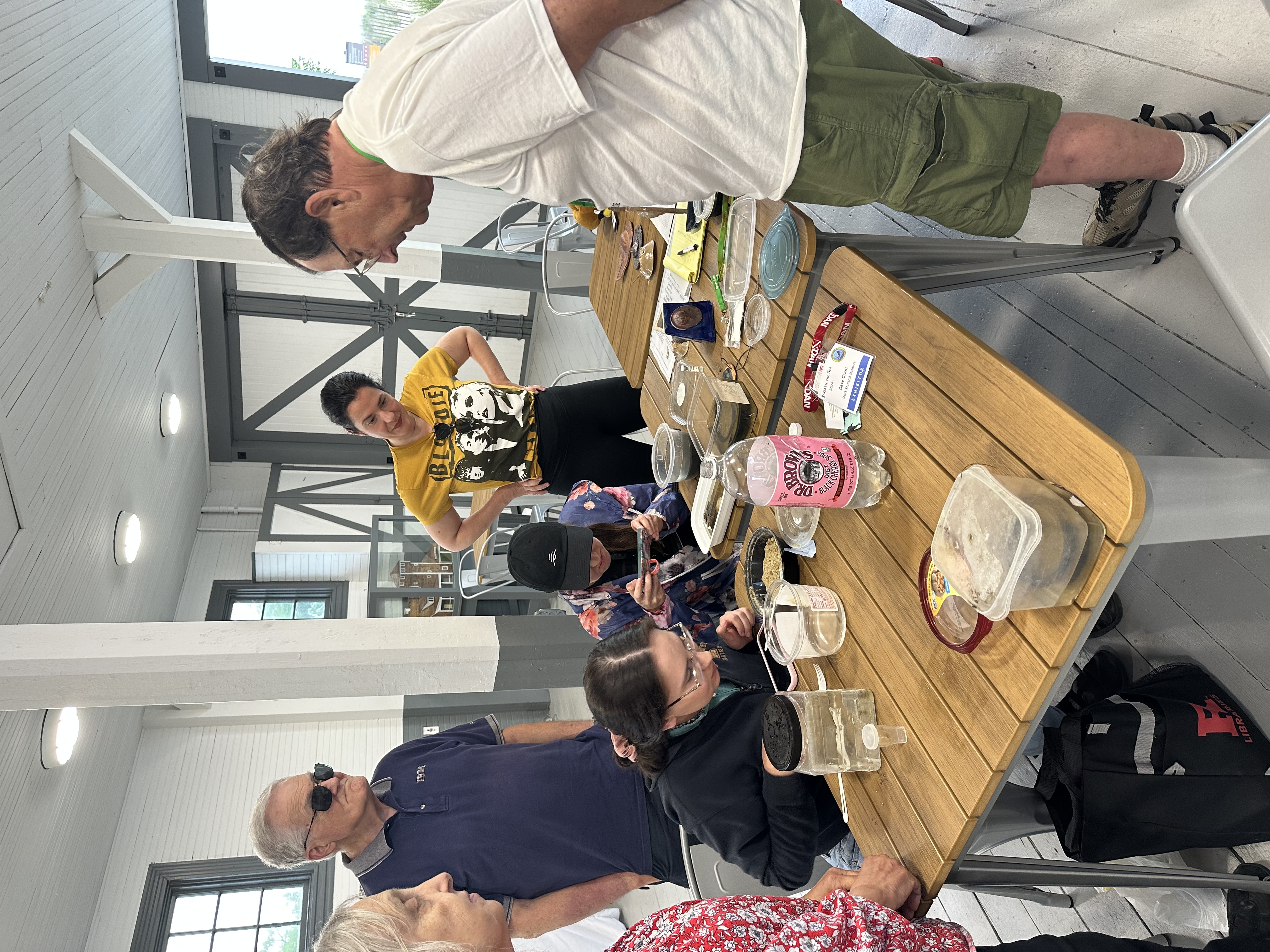 group of program participants learning about horseshoe crab eggs by sifting through sand and adding them to salt water with with dave grant. 